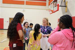 kids and staff in a group smiling in the gym